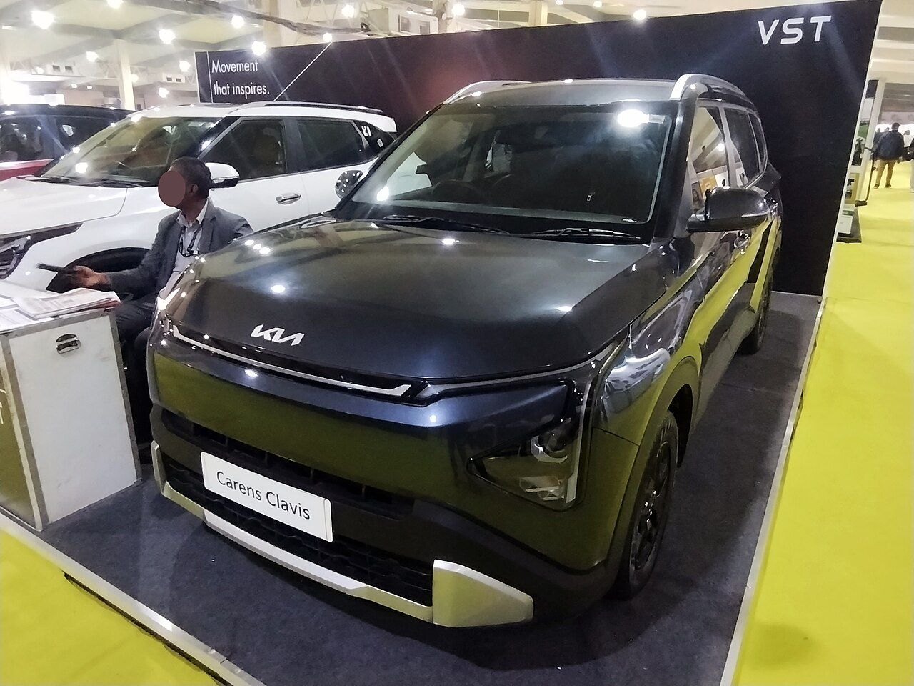 Kia Carens: Carens gris oscuro del diseño actual (Clavis), en una exposición, vista delantera de tres cuartos